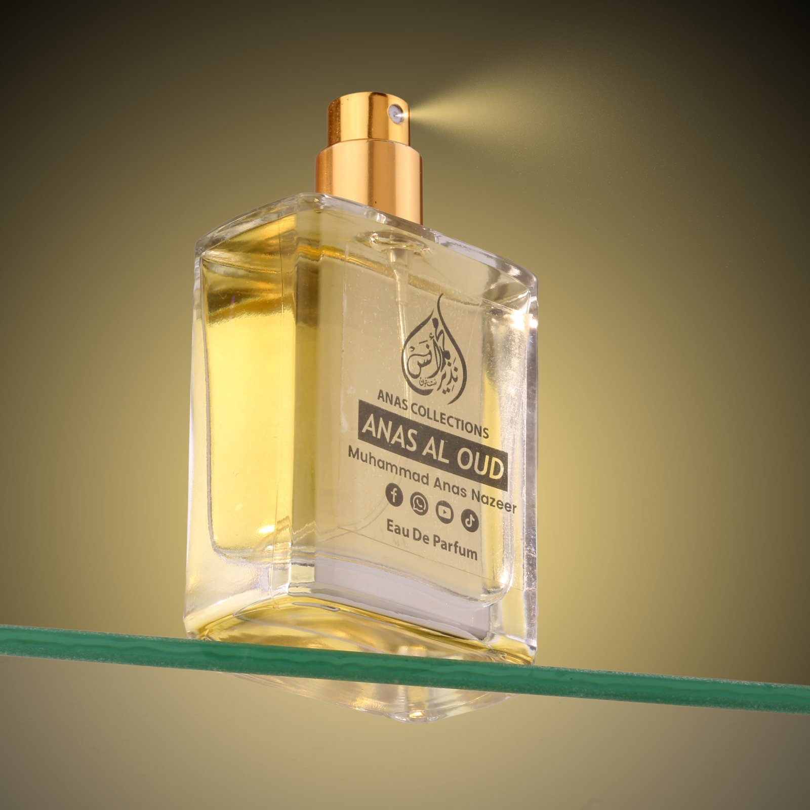 Close-up action shot of Anas Al Oud luxury perfume mist spraying from a gold applicator.