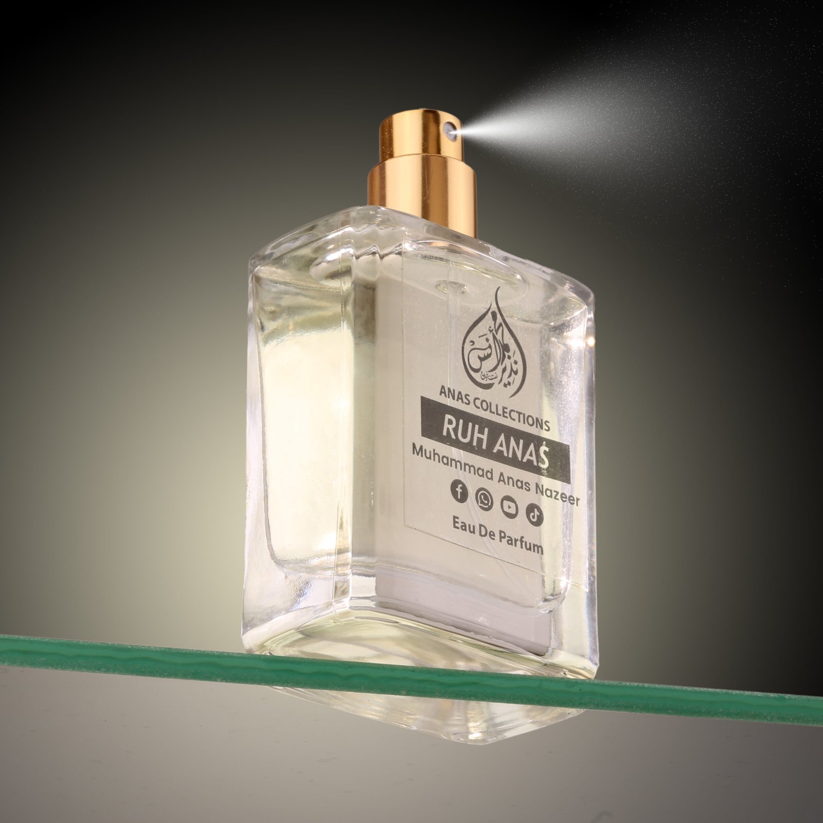 Close-up action shot of Ruh Anas luxury perfume spraying from a golden nozzle.